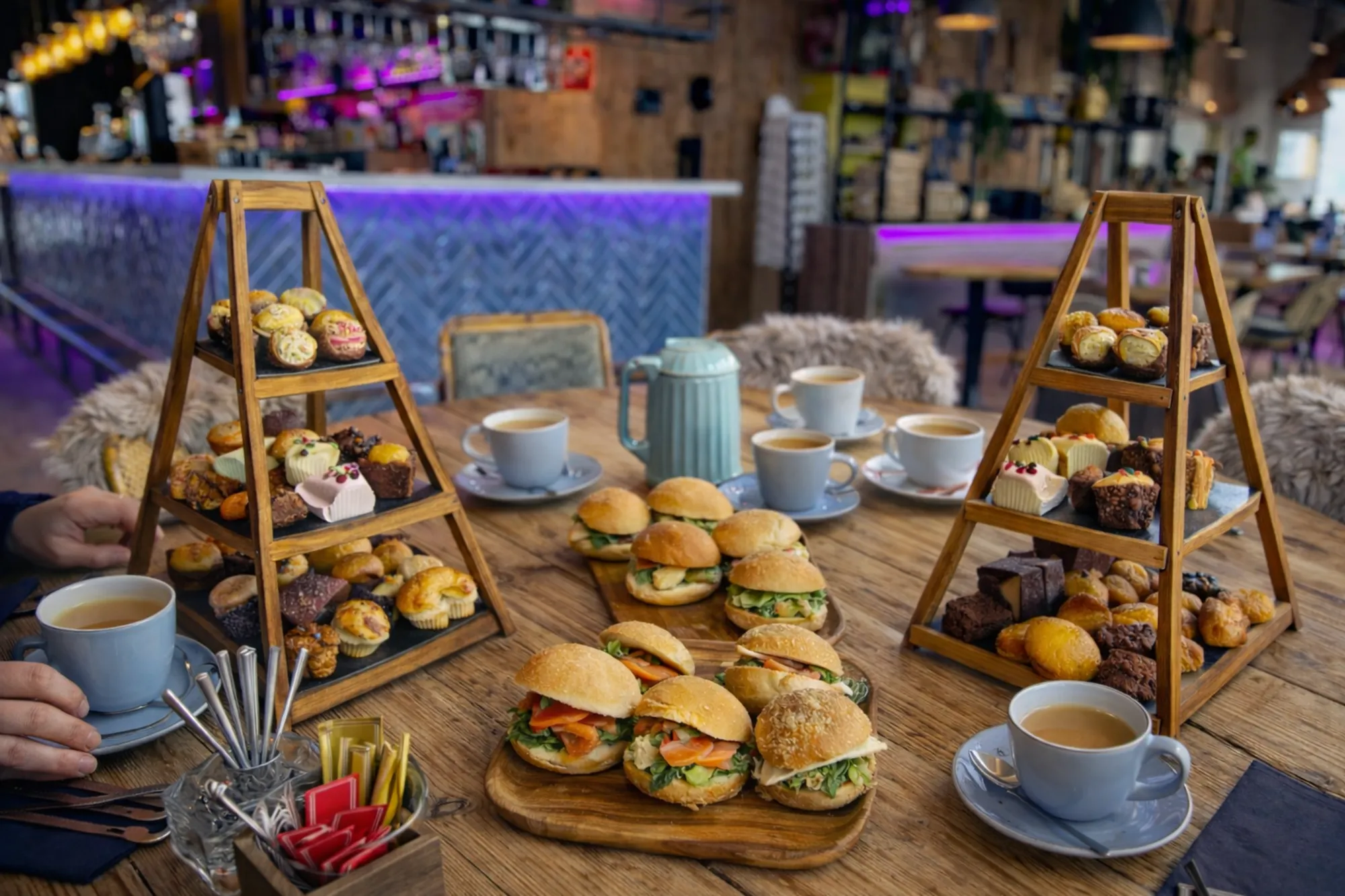 High tea bij Eemhof Winterlodge met een sfeervol gedekte tafel vol zoete en hartige lekkernijen, warme dranken en een gezellige winterse ambiance.